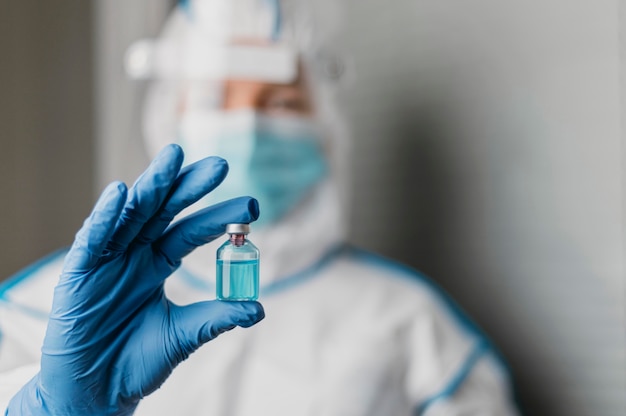 Photo female doctor holding a vaccine bottle