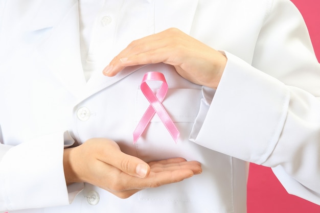 Female doctor holds breast cancer awareness ribbon, close up