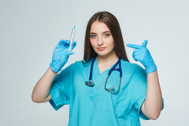 Female doctor holds a syringe in her hand