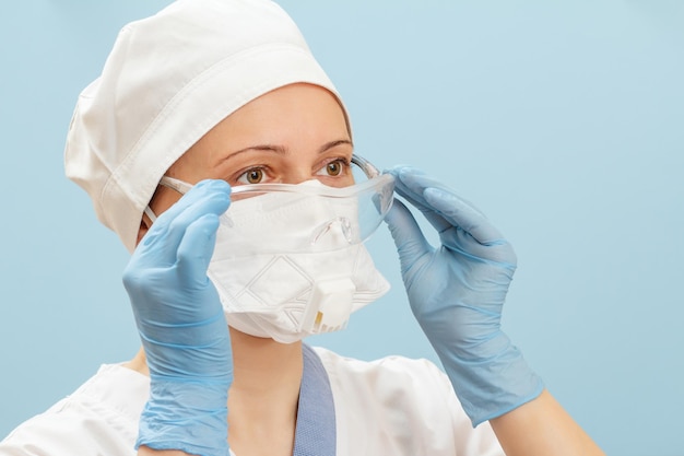 공기 중 바이러스에 대한 보호로 안경과 인공 호흡기에 여성 의사