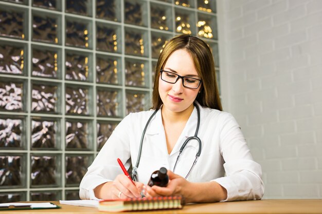 Female doctor is fiiling a prescription