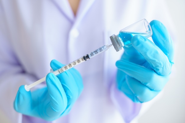 Female doctor in laboratory holding a syringe