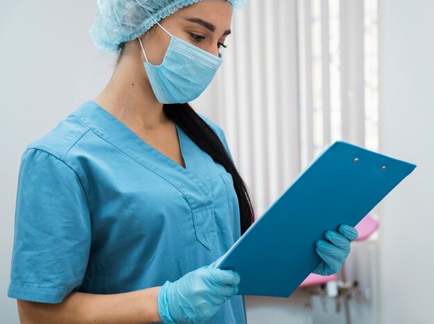 Photo female doctor looking on a clipboard