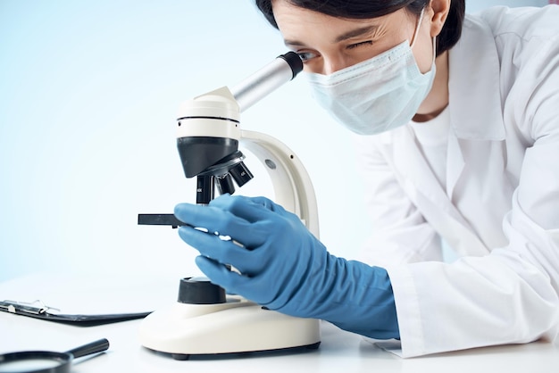 顕微鏡バイオテクノロジー研究所を通して見ている女性医師
