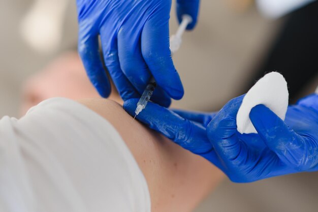 Female doctor making injecting using syringe to male patient in hospital Senior man taking injection for flu in clinic Female doctor vaccinating a man