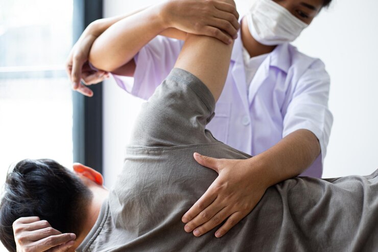 Photo 女性医師が男性をマッサージしている