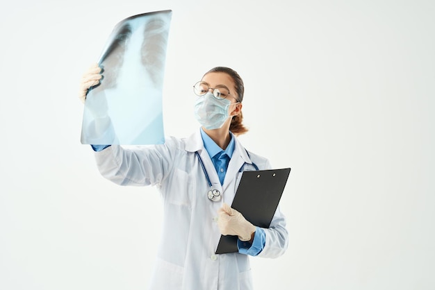 Foto medico femminile nell'esame ospedaliero dei raggi x della mascherina medica