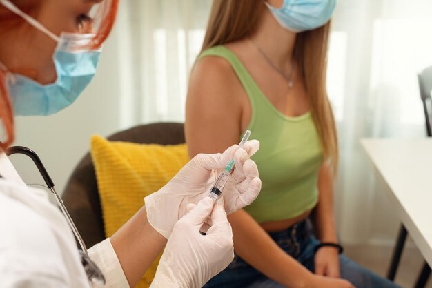 Female doctor or nurse giving shot or vaccine to a patient's shoulder