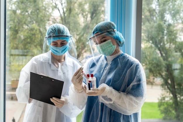 Female doctor and nurse in personal protective wear are discussing    about result test patient on coronavirus. health lifestyle