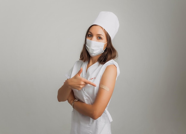 A female doctor or nurse shows her hand with a plaster after vaccination. vaccination concept.