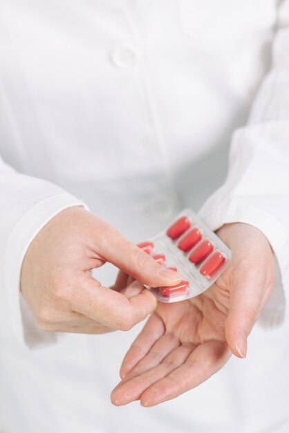 Female doctor offering red tablets to patient