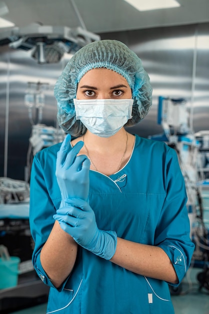 Female doctor in operating room in a special uniform injecting medicine through the patient