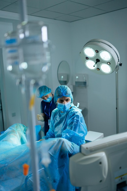 A female doctor performs an operation in a sterile operating room Surgical intervention operation Doctor in sterile clothes