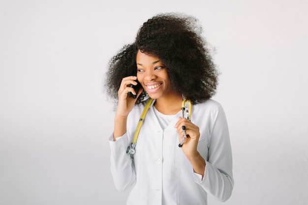 Female doctor Preparation medical equipment. An  female medical doctor with a stethoscope in hospital on white background and talking on the phone