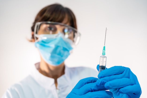 Female doctor preparing the injection of the coronavirus vaccine. Antibodies, immunize population.