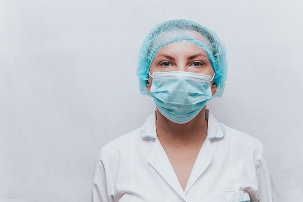 Female doctor in a protective mask and medical cap