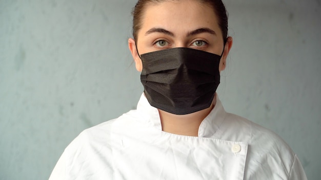 Female doctor puts on a medical mask