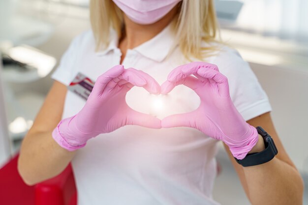 Female doctor's hands showing heart shape. Doctor's hands closeup. Medical help, prophylaxis or insurance concept. Cardiology care,health, protection and prevention. Healthy heart concept