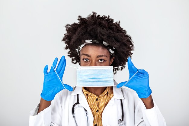   female doctor or scientist in protective facial mask over grey background