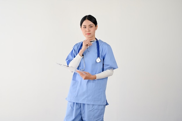 Женщина-врач в халате держит медицинский блокнот и думает о плане лечения