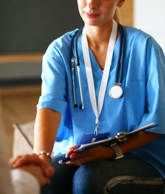 Female doctor shaking a hand in her office