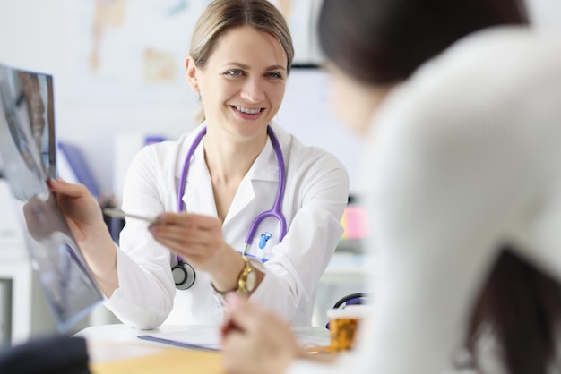 Female doctor show x ray result to patient and explain professional specialist joking about disease