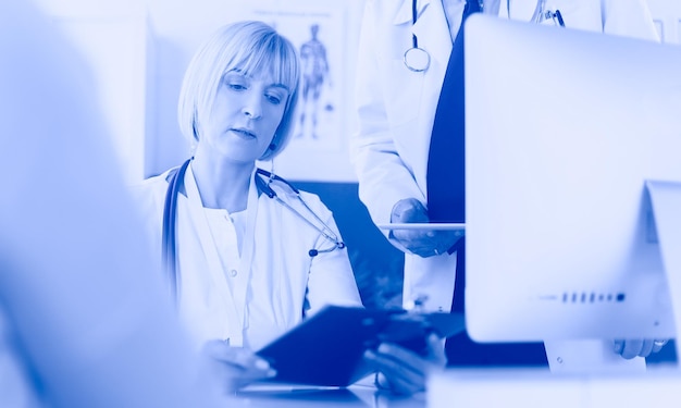 Photo female doctor sitting at table with laptop working