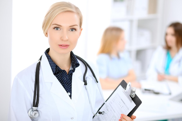 Female doctor smiling on the background with patient.