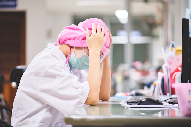 Dottoressa sotto stress e mal di testa lavorando sodo davanti al computer