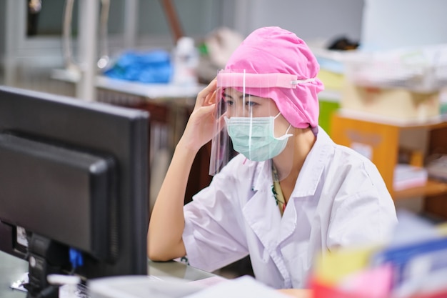 Female doctor under stress and headache working hard in front of computer