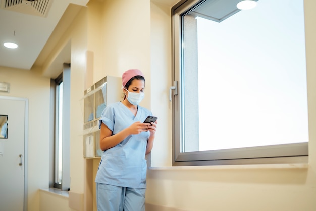 Female doctor surgeon using smart phone