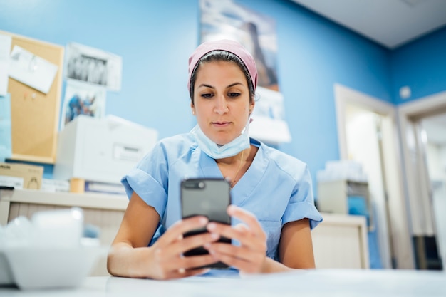 Female doctor surgeon using smart phone