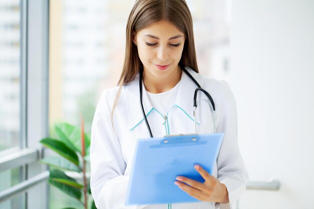 Female Doctor In Surgery Reading Patient Notes