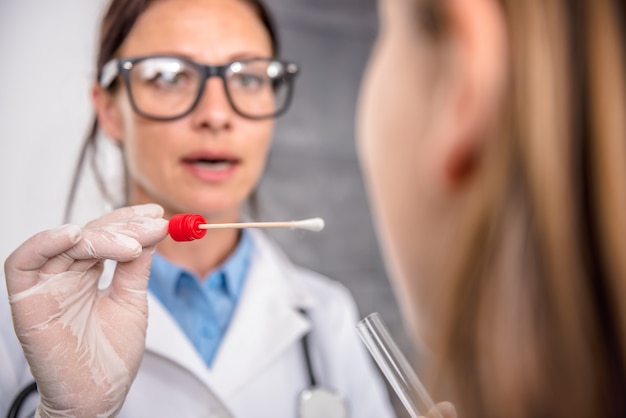 Female doctor taking a throat culture