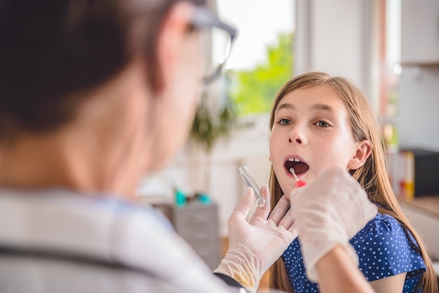 Female doctor taking a throat culture