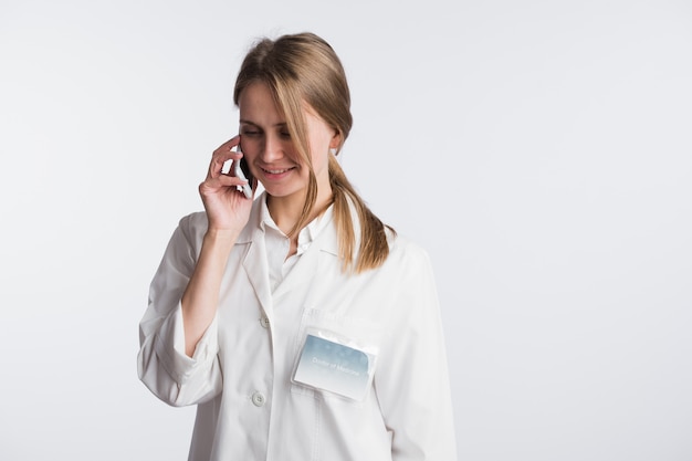 Female doctor talking on the cell phone isolated over white