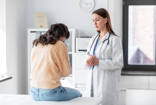 female doctor talking to sad woman at hospital