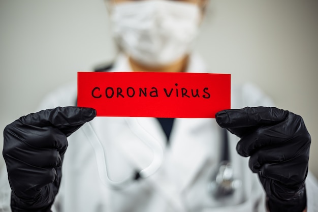 Photo female doctor tearing a coronavirus red paper