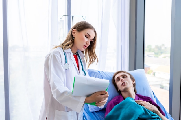 Female doctor therapeutic advising with positive emotions  hold clipboard to a man patient on Bed in white hospital background.