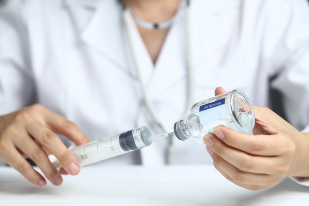 Photo female doctor using syringe