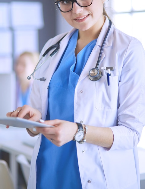 Female doctor using tablet computer in hospital lobby