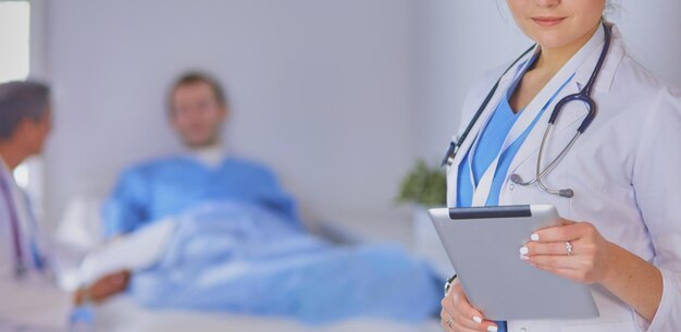 病院のロビーでタブレットコンピューターを使用している女性医師