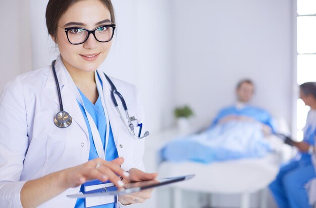 Female doctor using tablet computer in hospital lobby