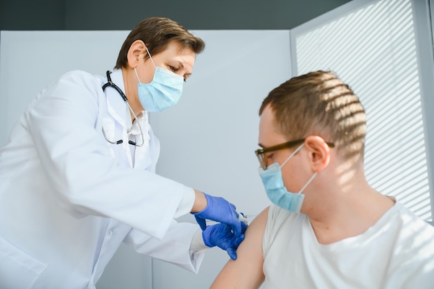 Female doctor vaccinating a man