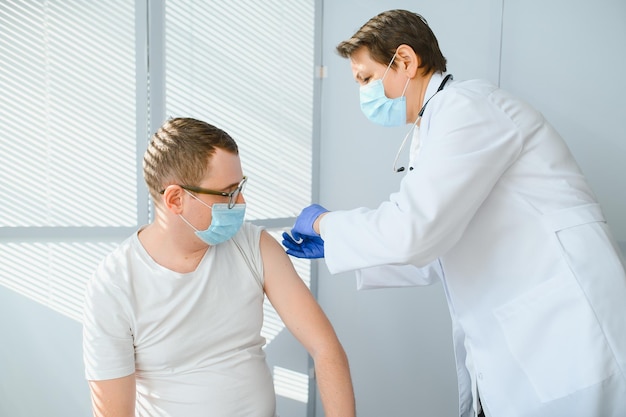 Female doctor vaccinating a man