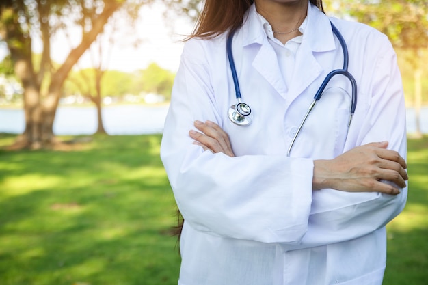 Female doctor wearing a medical gown with a stethoscope Standing in the garden