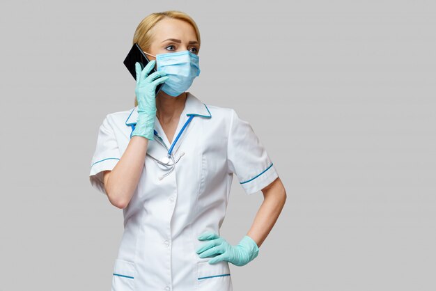 Medico femminile che indossa maschera e guanti protettivi