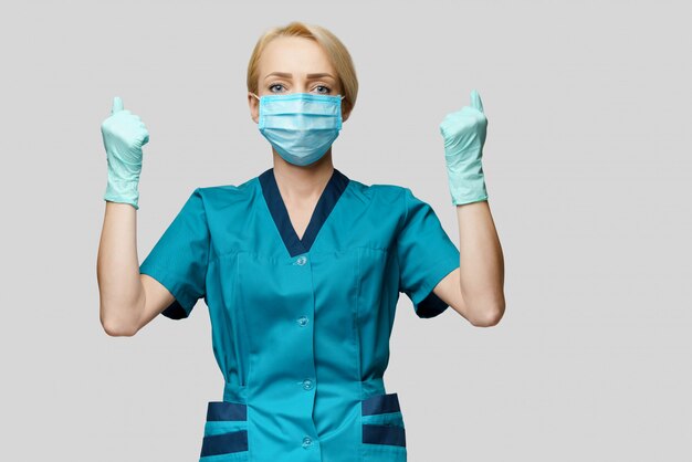 Photo female doctor wearing protective mask and latex gloves with win gesture