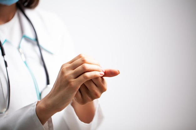 Photo female doctor in a white coat disinfects her hands with antiseptic