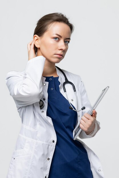 A female doctor in a white coat with a stethoscope holds a laptop in her hands Electronic issuance of recommendations and an appointment with a doctor